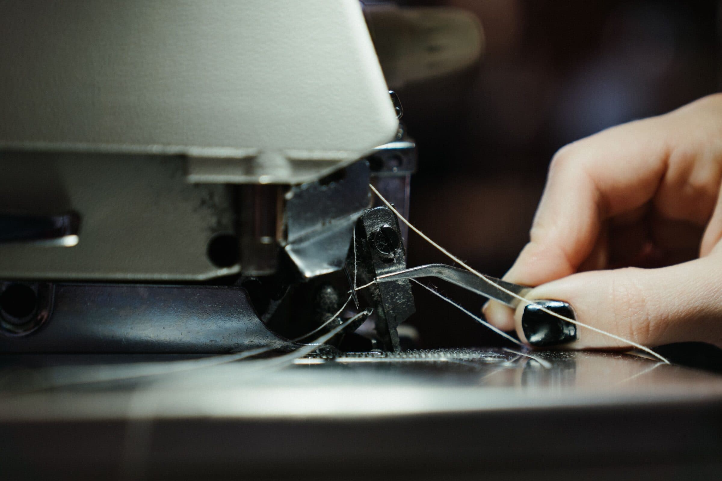 Atelier — couture à la machine, gros plan sur le fil et l'aiguille